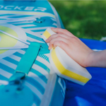 Person cleaning the paddle board with iROCKER Scuff Eraser XL | Bundle
