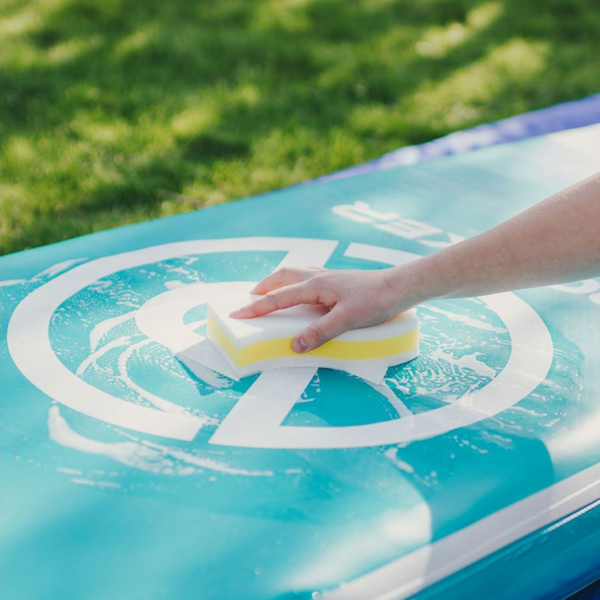 Person cleaning the paddle board with iROCKER Scuff Eraser XL  Bundle
